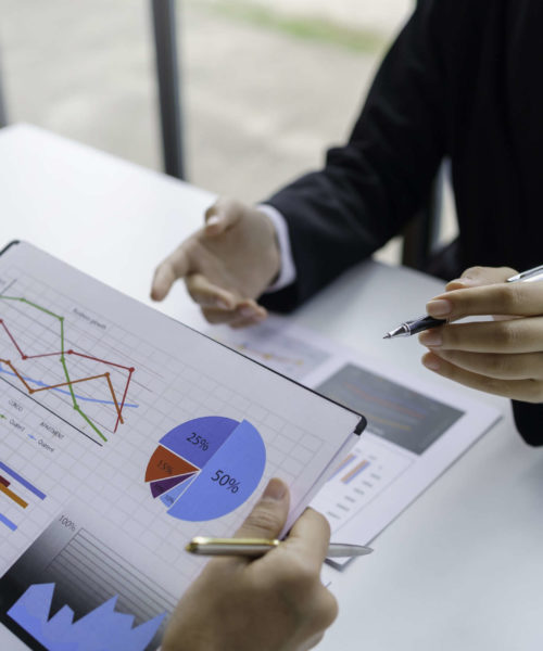 Business people consulting and planning work, looking at chart g Business people consulting and planning work, looking at chart growth details and thinking of new projects.